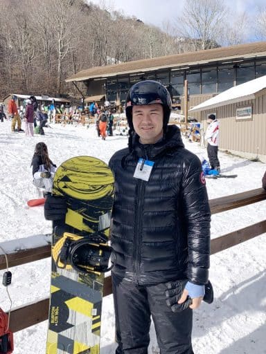 Azat Agishev holds a snowboard at a resort