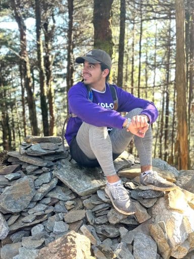 Harry Koutroumanis sits on a stack of rocks during a hike