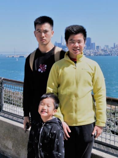 Jeremy Cheng and two others with a city in the background