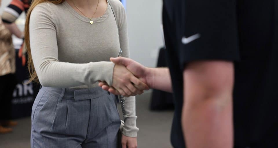 A student shakes hands with someone