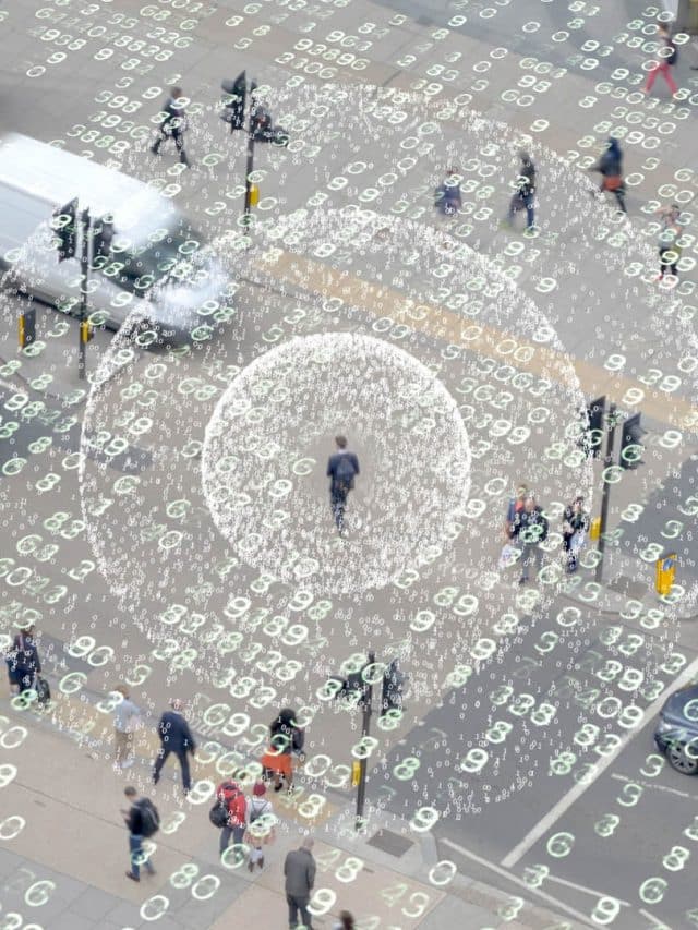 People walking on sidewalks and crosswalks in a city with numbers representing data overlaid across the plane and in concentric circles radiating out from the center