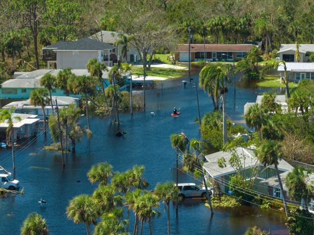 A kayaker navigates a flooded neighbohood after Hurricane Ian