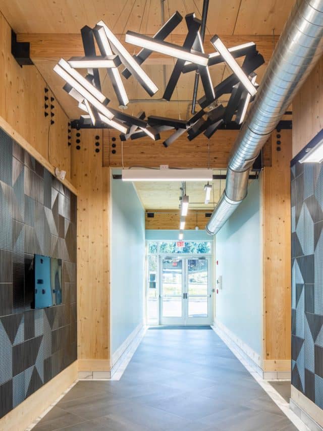 The hallway in a new construction shows exposed wood features in framing and ceiling