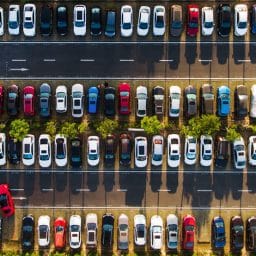 An aerial view of a parking lot with many cars and only one empty parking spot