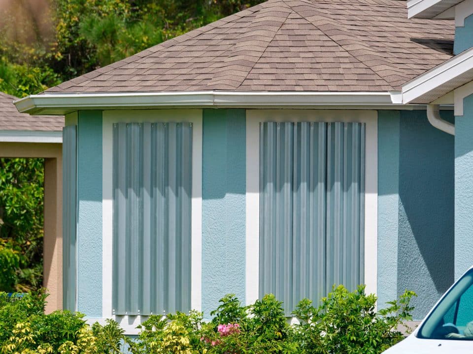 A home with hurricane shutters on two windows