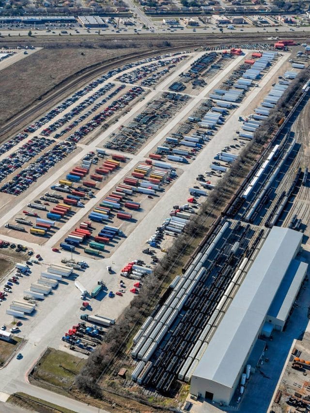 An aerial view of a storage facility including many trucks, rail cars, and storage containers