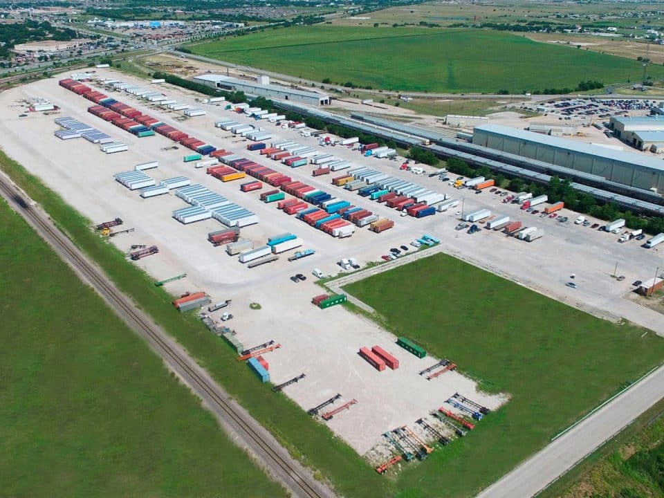 An aerial view of an industrial storage facility where many trucks and storage containers are parked