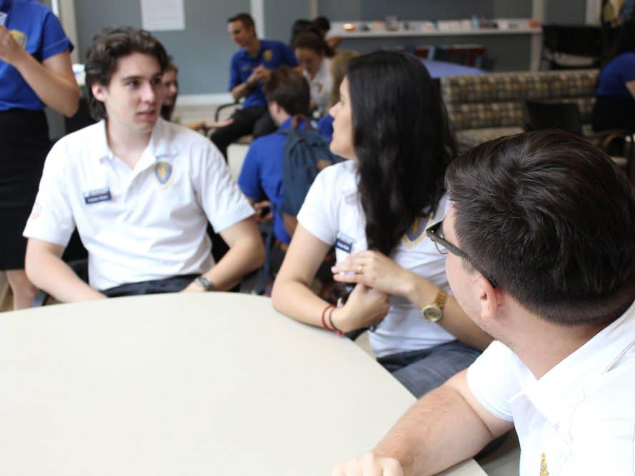 Three FLA students in discussion around a table