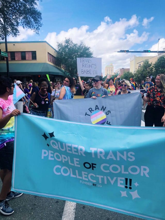 Students gather with banners at a Pride Parade in Gainesville