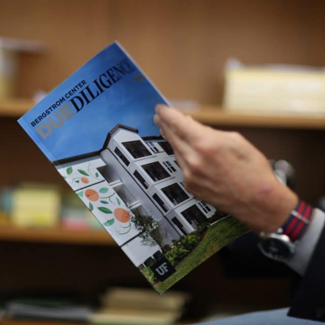 Hand holding an issue of the Due Diligence print magazine
