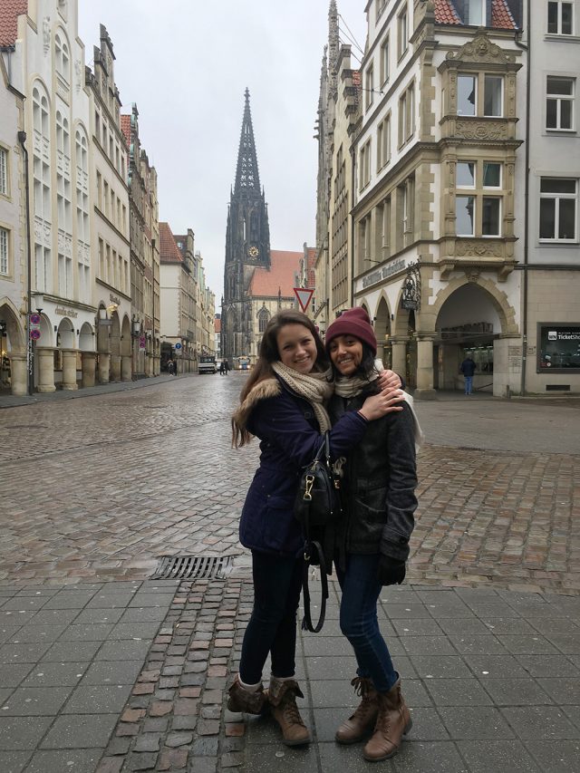 Two young women in Münster, Germany with St. Lambert's Church in the background