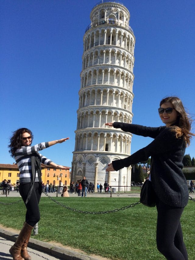 Two young women Gator Chomp with the Leaning Tower of Pisa in the background, Pisa, Italy