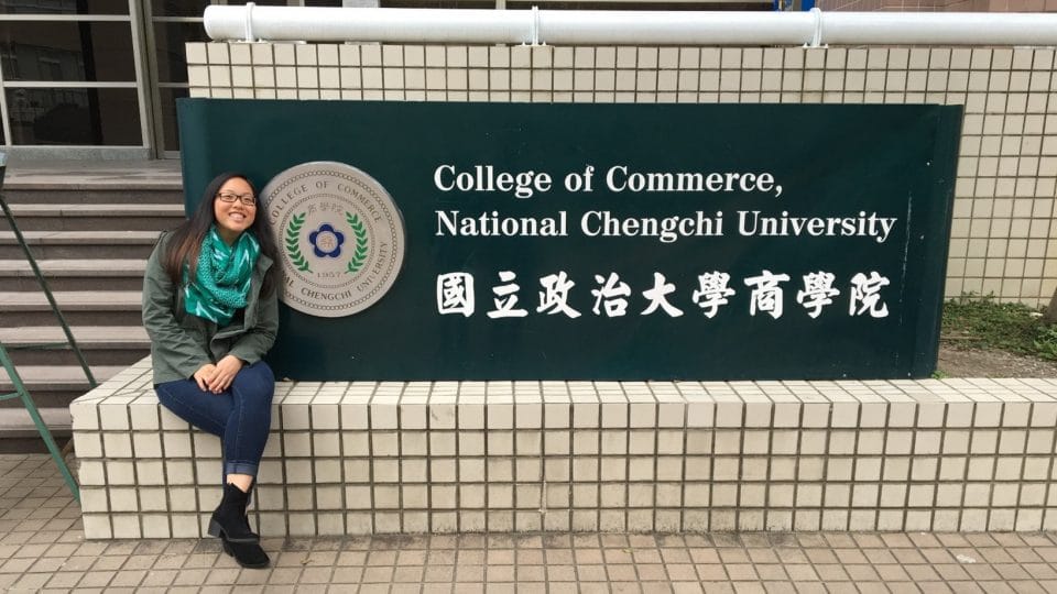 Student in front of the College of Commerce sign at National Chengchi University in Taiwan