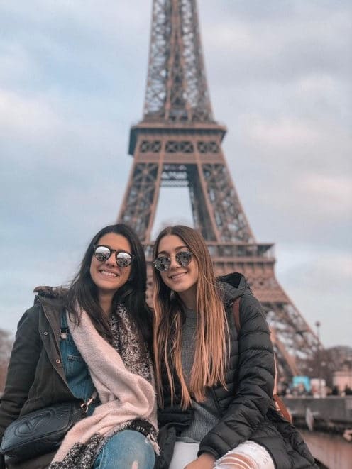 Two students sitting in front of the Eiffel Tower in Paris, France.