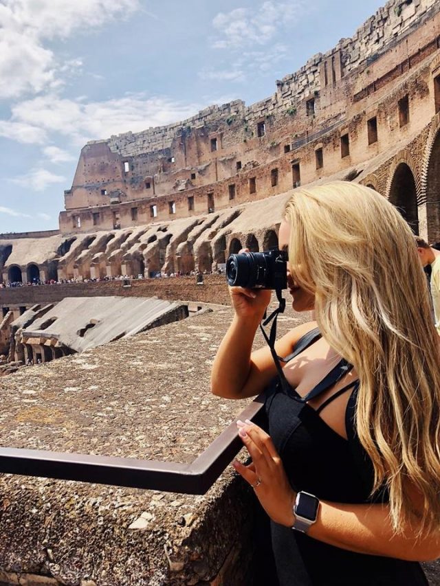 Student with binoculars inside the Colosseum in Rome, Italy.