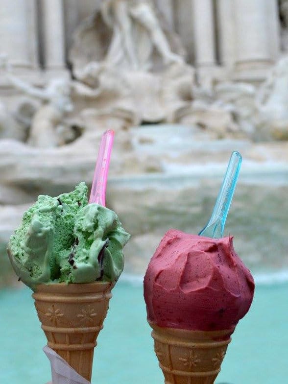 Two gelato cones with Trevi Fountain in the background in Rome, Italy
