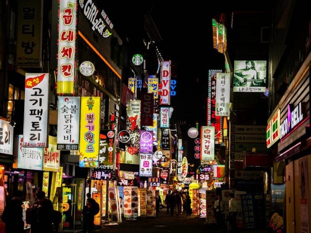 Signs light up the street at night in Seoul, South Korea