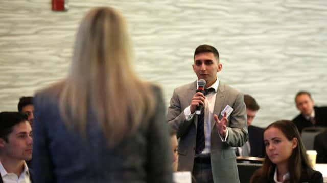 Student with a microphone asks the presenter a question at Professional Development Day
